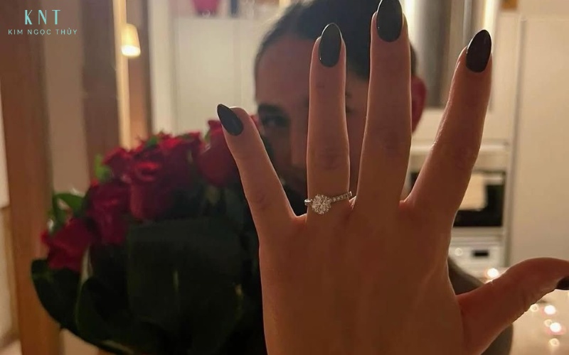 Giơ tay đeo nhẫn khi cầm bó hoa cách khoe nhẫn tinh tế, nổi bật giữa khung hình đầy cảm xúc