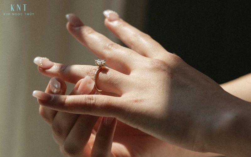 Bàn tay thả lỏng, hậu cảnh gọn gàng và ánh sáng hài hòa giúp chiếc nhẫn nổi bật một cách tinh tế