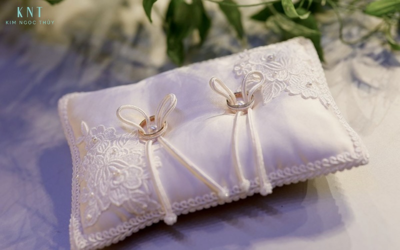 Gối nhẫn thêu ren, thắt dây vừa phải, tôn vẻ trang trọng và hài hòa trong nghi thức trao nhẫn